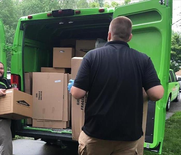 SERVPRO employees loading box in a green van